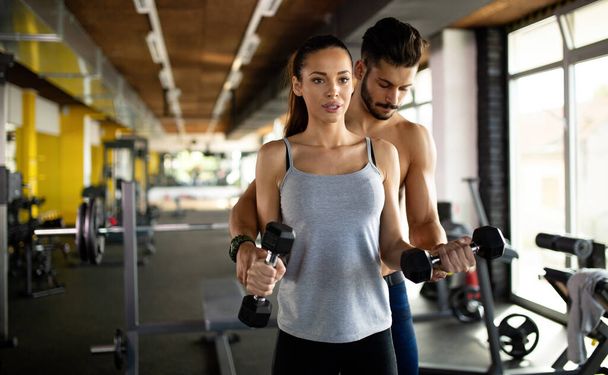 Young personal trainer assisting woman to lose weight. Sport exercise people healthy lifestyle concept - Φωτογραφία, εικόνα