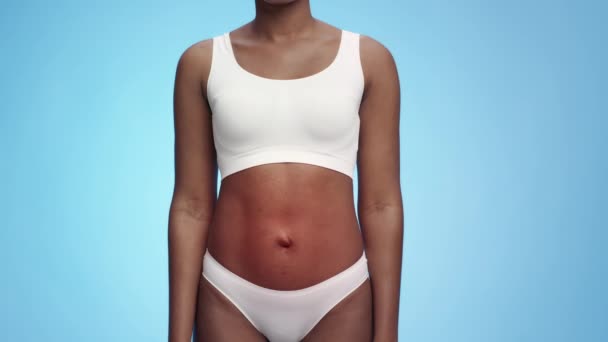 Vrouwelijke gezondheidsproblemen. Studio shot van onherkenbare zwarte vrouw in ondergoed met rode pulserende maag - Video