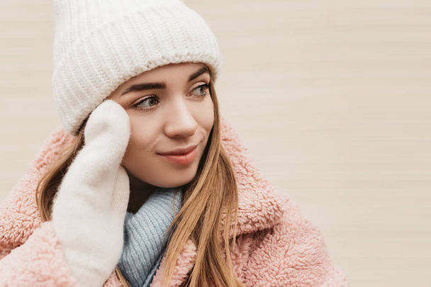 若いかなり笑みを浮かべて女性は、カメラのニット帽のミトンを着て見て。寒い天候、冬の休日、旅行。新年のクリスマスフェアの装飾、バレンタインデーのコンセプトコピースペース - 写真・画像