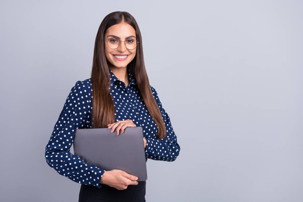Fénykép a pozitív szabadúszó munkás hölgy hold laptop visel szemüveg pontozott blúz elszigetelt szürke színű háttér - Fotó, kép