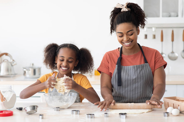 Joyful african american mother and daughter making pastry dough - Photo, Image