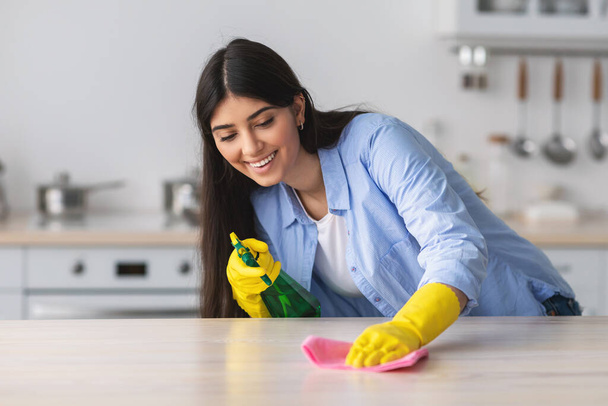 Veselý mladý žena čištění stůl s látkou - Fotografie, Obrázek