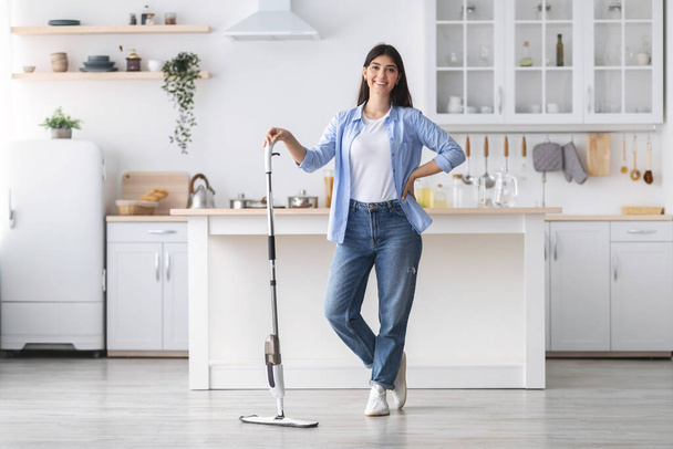Retrato de mujer alegre limpiando piso con aerosol fregona, posando - Foto, Imagen