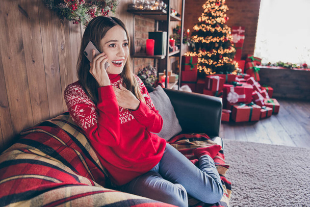Photo of charming excited mature lady wear red pullover communicating modern gadget christmas congratulations indoors house home room - 写真・画像