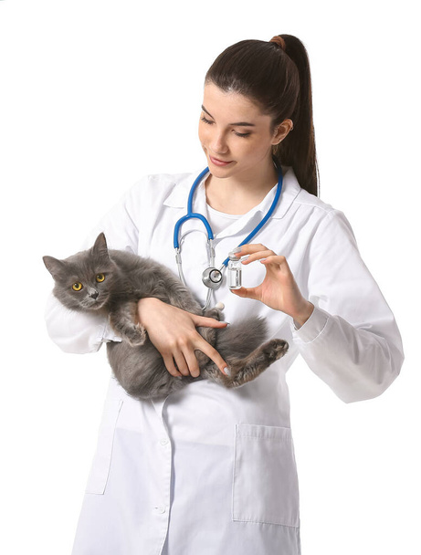 Tierärztin mit süßer Katze und Impfstoff auf weißem Hintergrund - Foto, Bild