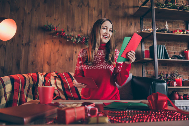 Photo of impressed excited mature lady wear red pullover smiling sending christmas greetings indoors house home room - 写真・画像