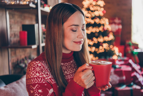 Photo of dreamy charming mature lady wear red pullover smiling enjoying christmas drink indoors house home room - Фото, изображение