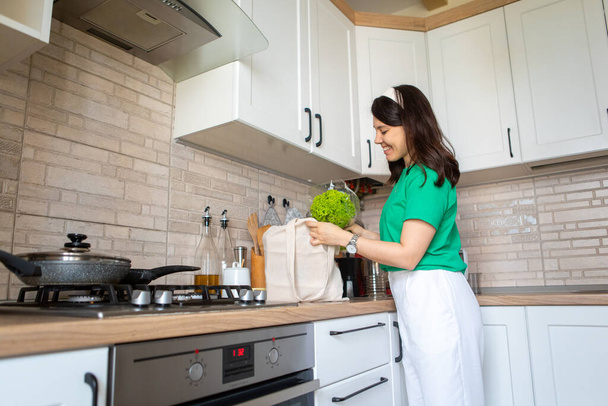 mujer desmonta compras en casa cocina ama de casa concepto - Foto, Imagen