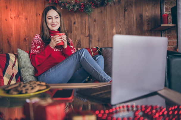 Photo of shiny dreamy mature lady wear red pullover drinking eggnog watching modern device christmas program indoors house home room - Photo, Image