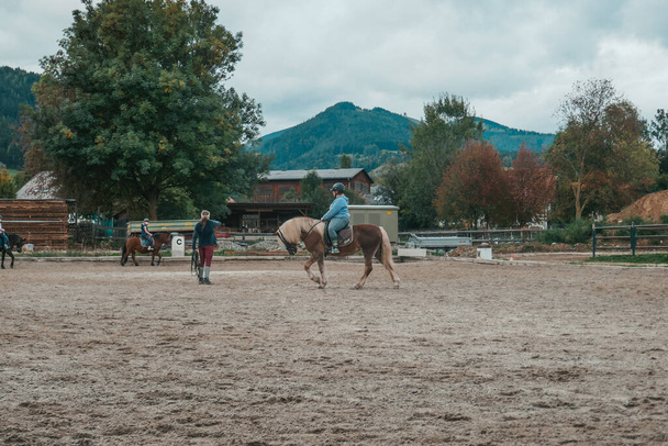 Beaux chevaux dans une ferme en Autriche. Une petite fille fait du sport équestre. L'enfant monte à cheval. - Photo, image