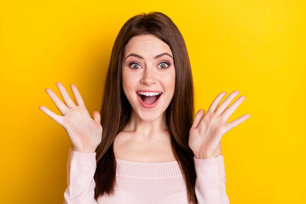 Photo of impressed brunette lady hands up wear pink shirt isolated on yellow color background - Foto, Imagem