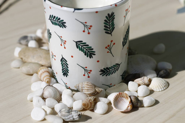 Bougie sur une table de couleur crème entourée de pierres décoratives - Photo, image