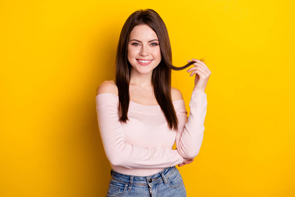 Photo of optimistic brunette lady hand hair wear pink shirt isolated on yellow color background - Foto, Imagem