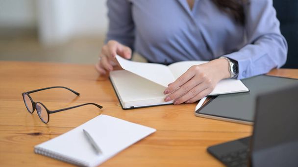 Businesswoman reading information on notebook and working with digital tablet. - Photo, Image