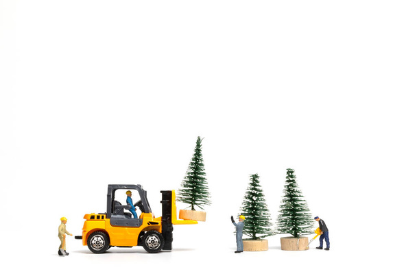 Миниатюрные люди, рабочий Подготовка елки на белом фоне, Рождество и с Новым годом концепция. - Фото, изображение