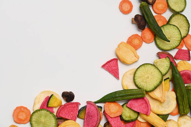 Getrocknete Gemüsechips mit grünem Rettich, Okra, Karotten, Kürbis, Roter Bete und Shiitake-Pilzen auf weißem Hintergrund. - Foto, Bild