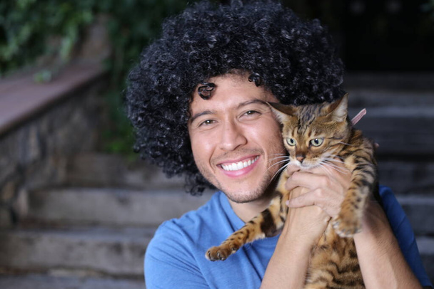 close-up portrait of handsome happy young man with his beautiful cat outdoors - Photo, Image