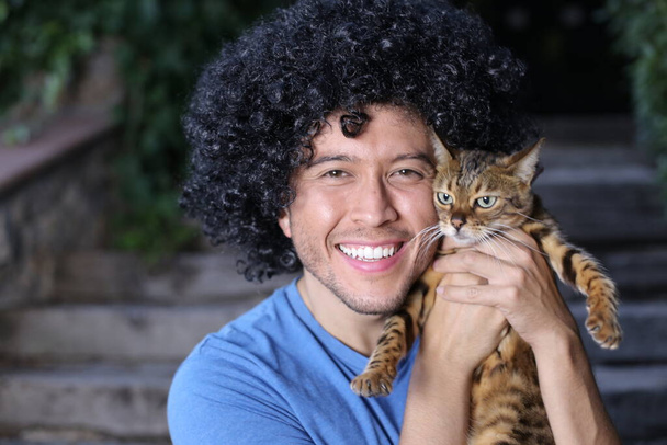 close-up portrait of handsome happy young man with his beautiful cat outdoors - Photo, Image