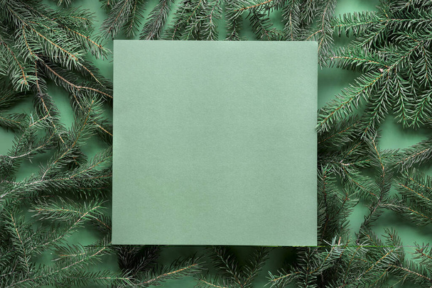 Green monochrome Christmas background with square copy-space, place for text. Natural undecorated Xmas tree, fir twigs. Flat lay, top view on dark green paper. Simple minimal textured winter background. - Foto, Bild
