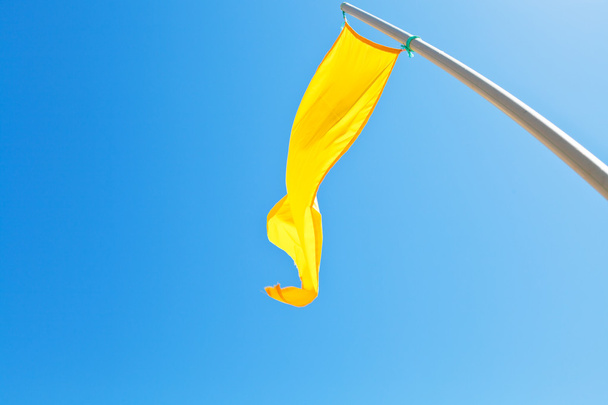 Spiaggia di sicurezza bandiera gialla con cielo blu
 - Foto, immagini