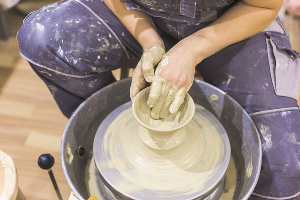 Keramische kunstenaar handen schimmel klei op aardewerk wiel. Creatieve workshop. - Foto, afbeelding