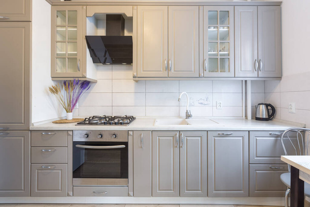 Wnętrze nowoczesnej beżowo-szarej kuchni w małym, inteligentnym apartamencie - Zdjęcie, obraz