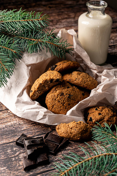 Chocolate chip homemade cookies and milk on dark wooden background - Foto, Imagen