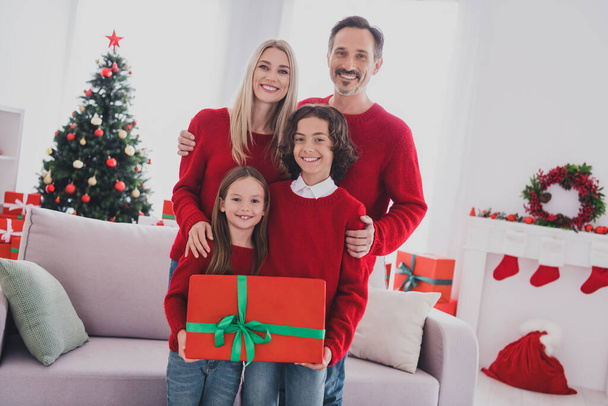 Portrait of adorable beautiful handsome cheerful family mom dad hugging holding giftbox festal at home house indoors - Фото, зображення