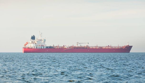 Великий червоний вантажний корабель (нафтовий танкер, довжиною 184 метри) плаває в Балтійському морі. Вантаж вантажів, логістика, глобальний зв'язок, економіка, промисловість, постачання, навколишнє середовище - Фото, зображення