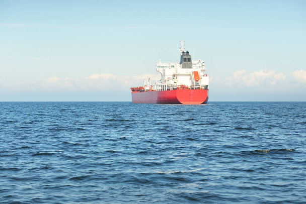 Большое красное грузовое судно (нефтехимический танкер длиной 184 метра) плавает по Балтийскому морю. Транспорт, логистика, глобальные коммуникации, экономика, промышленность, снабжение, окружающая среда - Фото, изображение