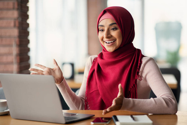 Emotionale muslimische Frau beim Online-Vorstellungsgespräch mit Laptop - Foto, Bild