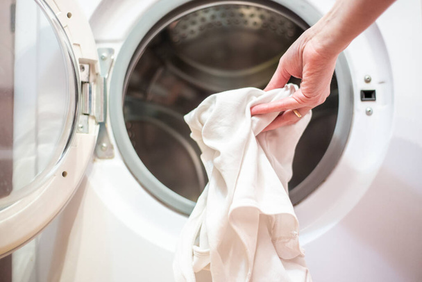 ανοιχτή πόρτα του πλυντηρίου ρούχων με άπλυτα - Φωτογραφία, εικόνα