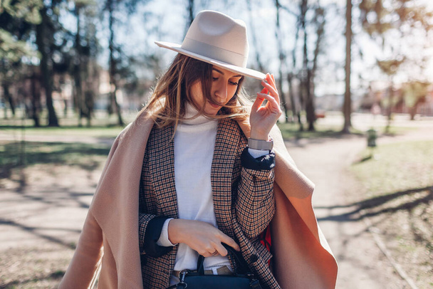 Close up portrait of fashionable woman wearing stylish clothes and accessories in park. Spring female outfit. - Foto, immagini