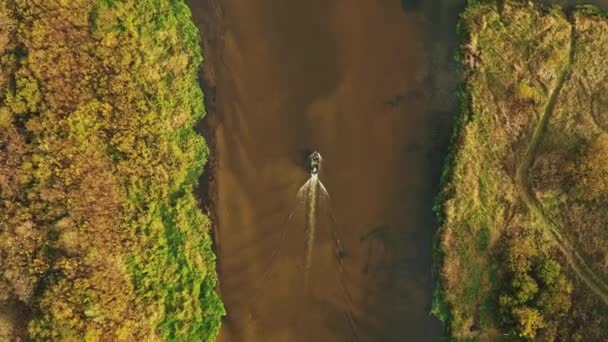 4K Luftaufnahme eines alten Bootes, das in der Herbstlandschaft des Flusses schwimmt. Top-Ansicht der schönen europäischen Natur aus der Höhe. Drohnenflug-Ansicht. Vogelauge erhöhte Ansicht des gelben üppigen Waldes in - Filmmaterial, Video