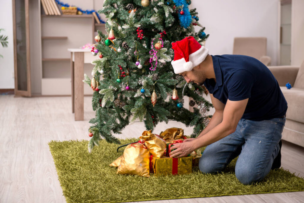 Genç adam Noel 'i evde kutluyor. - Fotoğraf, Görsel