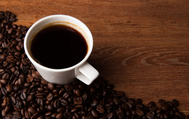 šálek černé kávy s pražená káva fazole na stole - Fotografie, Obrázek