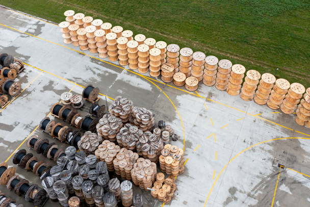 ポリプロピレンパイプを持つ木製のコイルの膨大な数。都市通信用ポリプロピレンパイプの製造・保管。上からの眺め - 写真・画像