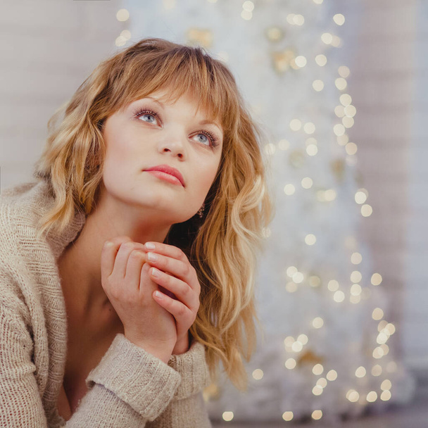 Dreamy woman in comfy clothes at home sitting by the Christmas tree  - Φωτογραφία, εικόνα