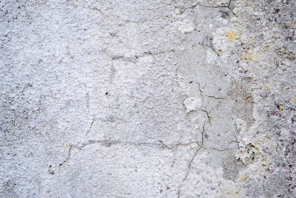 ραγισμένο τσιμεντένιο τοίχο καλυμμένο με γκρι επιφάνεια τσιμέντου ως φόντο. - Φωτογραφία, εικόνα