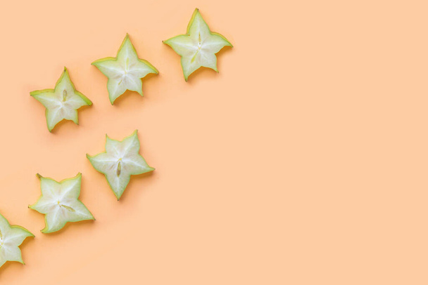 Green star fruit slices on pastel color background. - Foto, Imagen