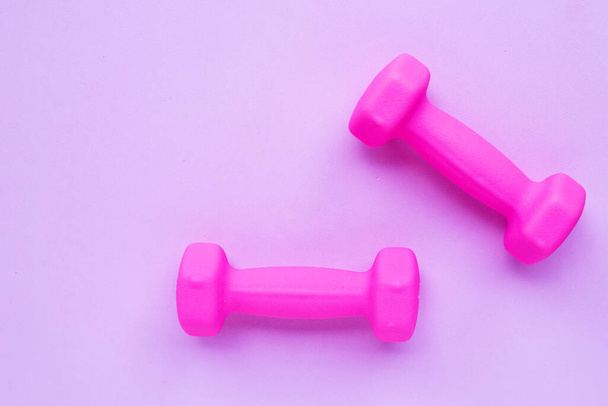 Top view of pink dumbbells on pink background. Copy space - Photo, image