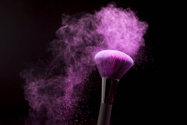 makeup brush with purple powder dust dark background. High quality photo - Photo, Image