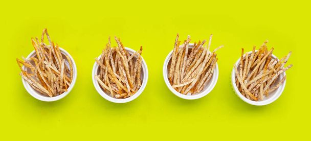 Fried taro sticks on green background. - Photo, Image