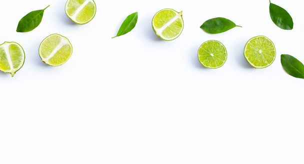 Fresh limes with green leaves on white background. Top view - Foto, Imagem