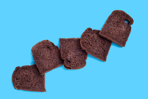 Темный какао хлеб на синем фоне. - Фото, изображение