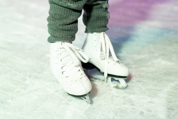 piernas en patines de hielo en primer plano, entretenimiento de invierno para niños. - Foto, imagen