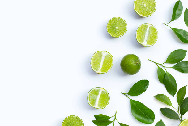 Fresh limes with green leaves on white background. Top view - Photo, image