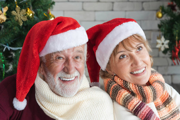 closeup portrait of two cheerful lovely sweet tender cute romantic married senior couple husband and wife in Santa hat celebrate Christmas together on Christmas and New Year celebration festival. - Фото, изображение