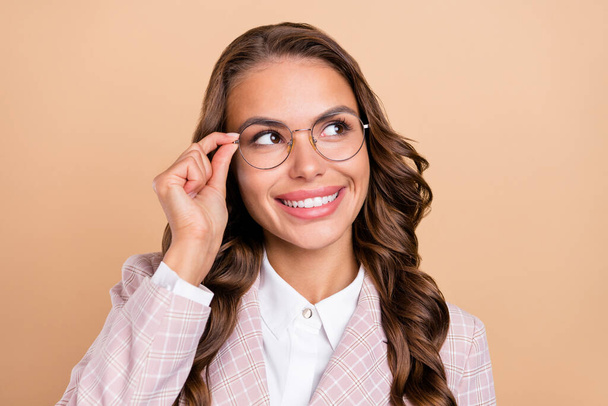 Photo of charming positive lady hand touch glasses look interested empty space isolated on beige color background - Φωτογραφία, εικόνα