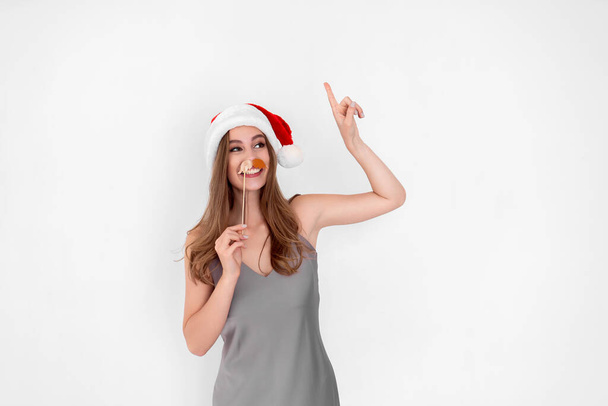 Funny Santa girl wears pretend mustache raises up hand with index finger. New Year. Advertisement  - Foto, Bild